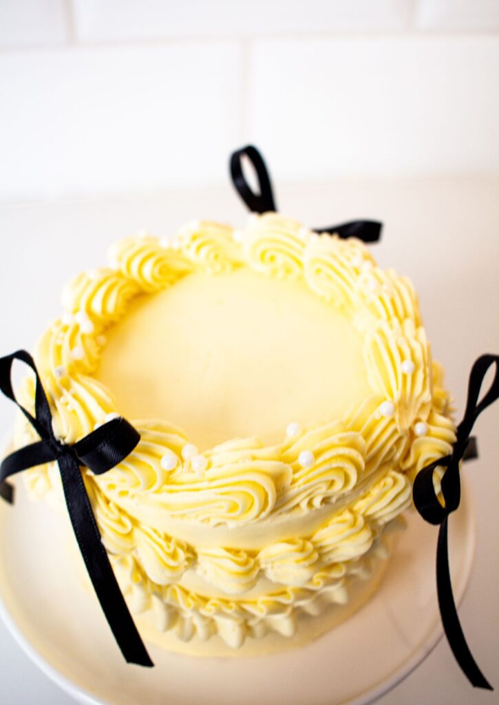 Bento Mini Celebration Cake - yellow buttercream with black bows top view