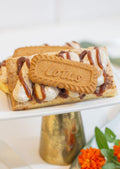 Biscoff Shortbread - butter shortbread bar with biscoff crumble, buttercream and whole Lotus cookie on gold cake stand
