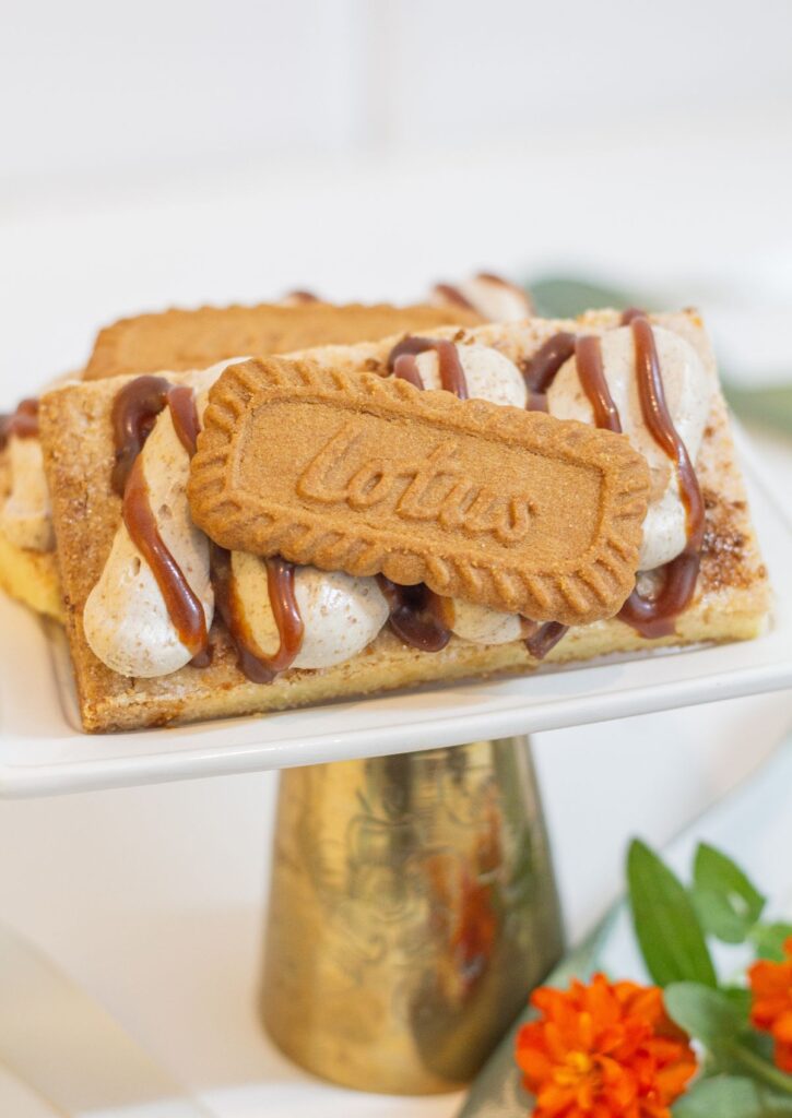 Biscoff Shortbread - butter shortbread bar with biscoff crumble, buttercream and whole Lotus cookie on gold cake stand