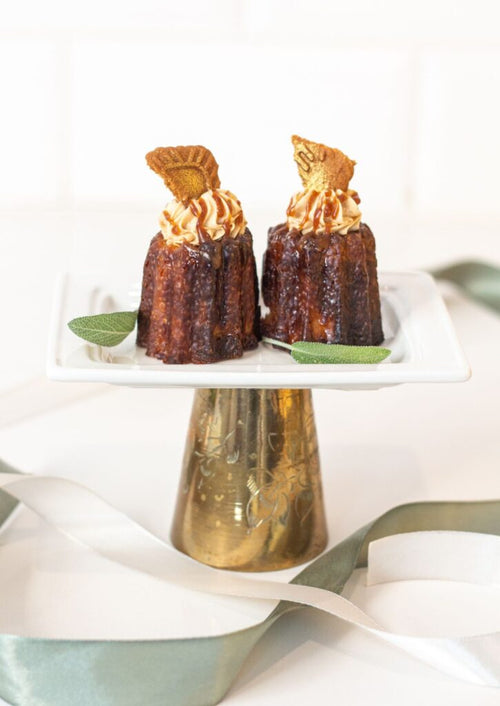 Canelé - caramel biscoff topping with biscoff wafer on gold cake stand