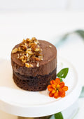 Mini Chocolate Mousse Cake - 7cm chocolate round with mousse and caramelized pecans on white cake stand