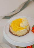 Mini Baked Cheesecake - lemon cream topping with whipped cream rosette on white cake stand
