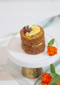 Moist Carrot Cake - stacked mini carrot cake with cream cheese rosette and pumpkin seeds on white gold cake stand