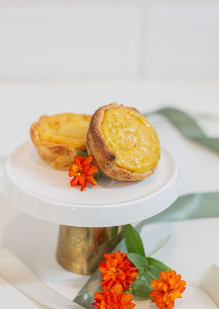 Pasteis de Nata - traditional Portuguese custard tarts on white cake stand