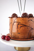 Rum Chocolate Mousse Cake - side view with chocolate drizzle and cherry garnish