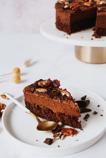 Pecan Wafer Chocolate Mousse Cake - slice showing dark chocolate mousse layer and pecan wafer topping on white plate with gold spoon