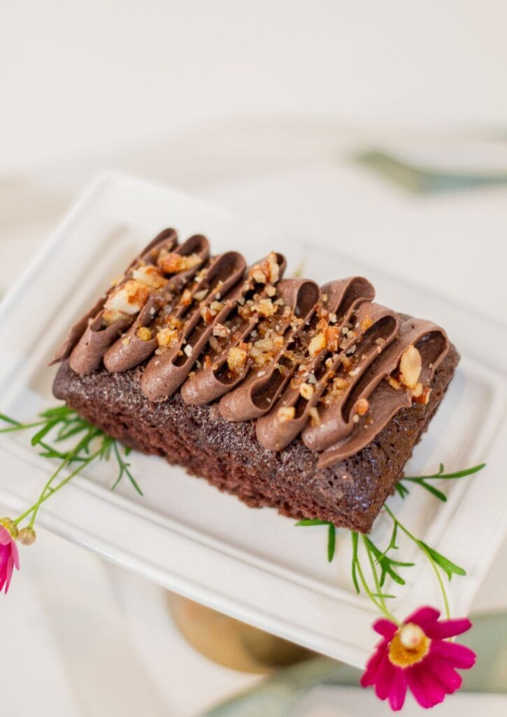 Vegan Chocolate Cake - top view on white cake stand with pink daisies